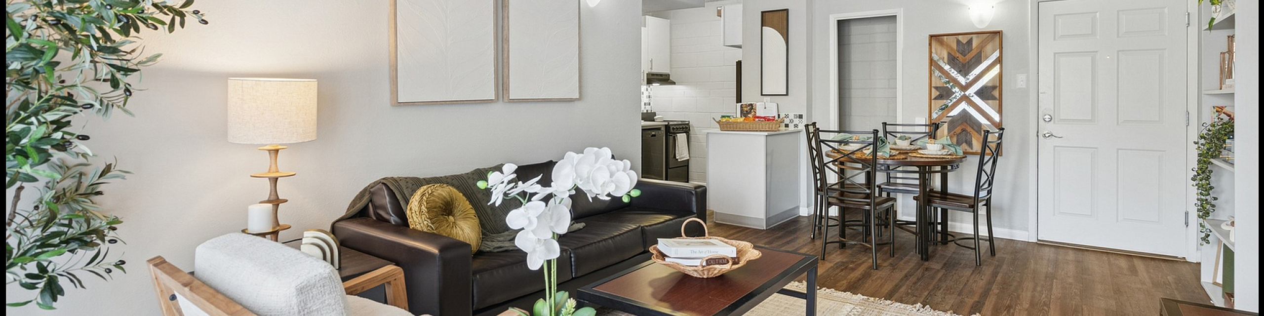 Cozy living room with modern decor, featuring a comfortable sofa, stylish armchairs, and a chic dining area with elegant wood flooring.