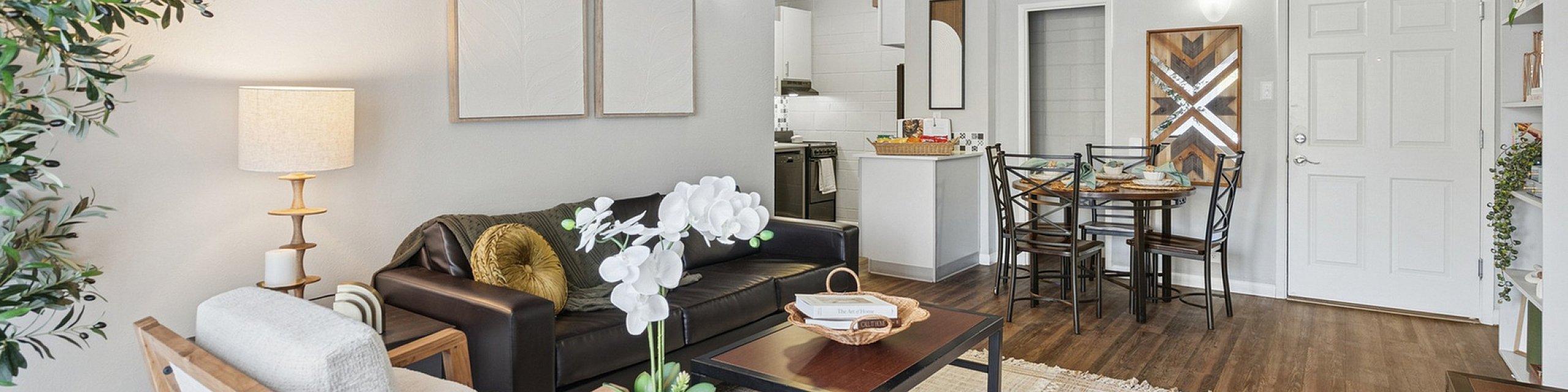 Modern living room with stylish decor, cozy seating, and open dining area leading to a bright kitchen.