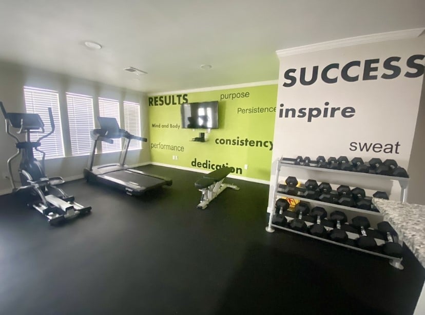 Inviting home gym with modern equipment, motivational wall quotes, and ample natural light for an energizing workout experience.