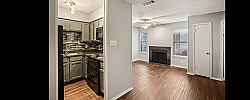 Charming apartment featuring a modern kitchen with sleek cabinetry, an inviting living area with a cozy fireplace, and elegant hardwood flooring.