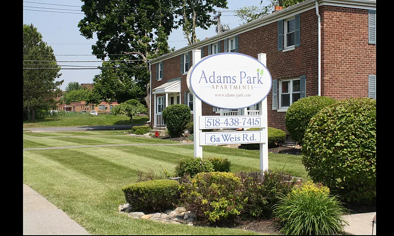 Beautiful brick Adams Park Apartments with well-maintained lush green lawns and inviting curb appeal, located on 6a Weis Rd.