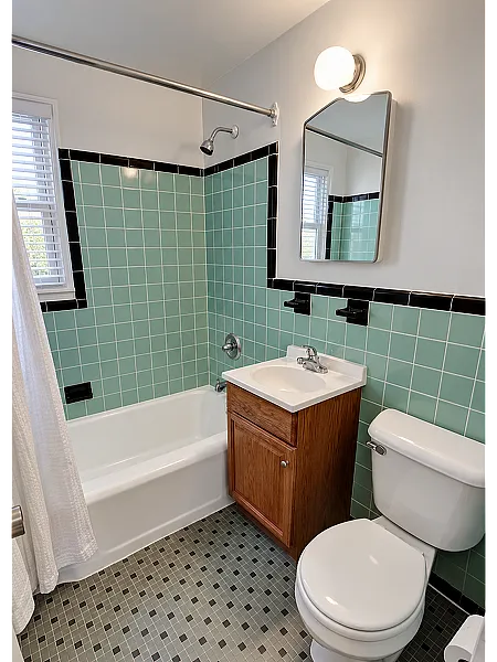 Full bathroom with tub, tile surround and vanity at Adams Park Apartments