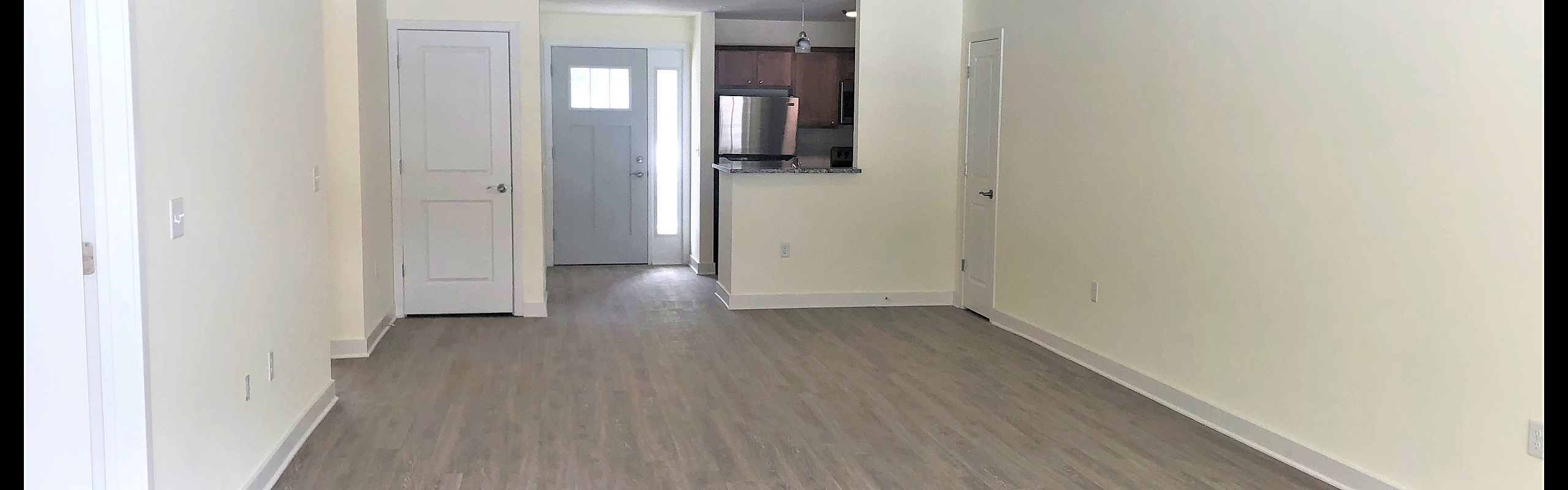 Open living area with wood-style flooring at Sunrise Solars Apartments in Latham, NY