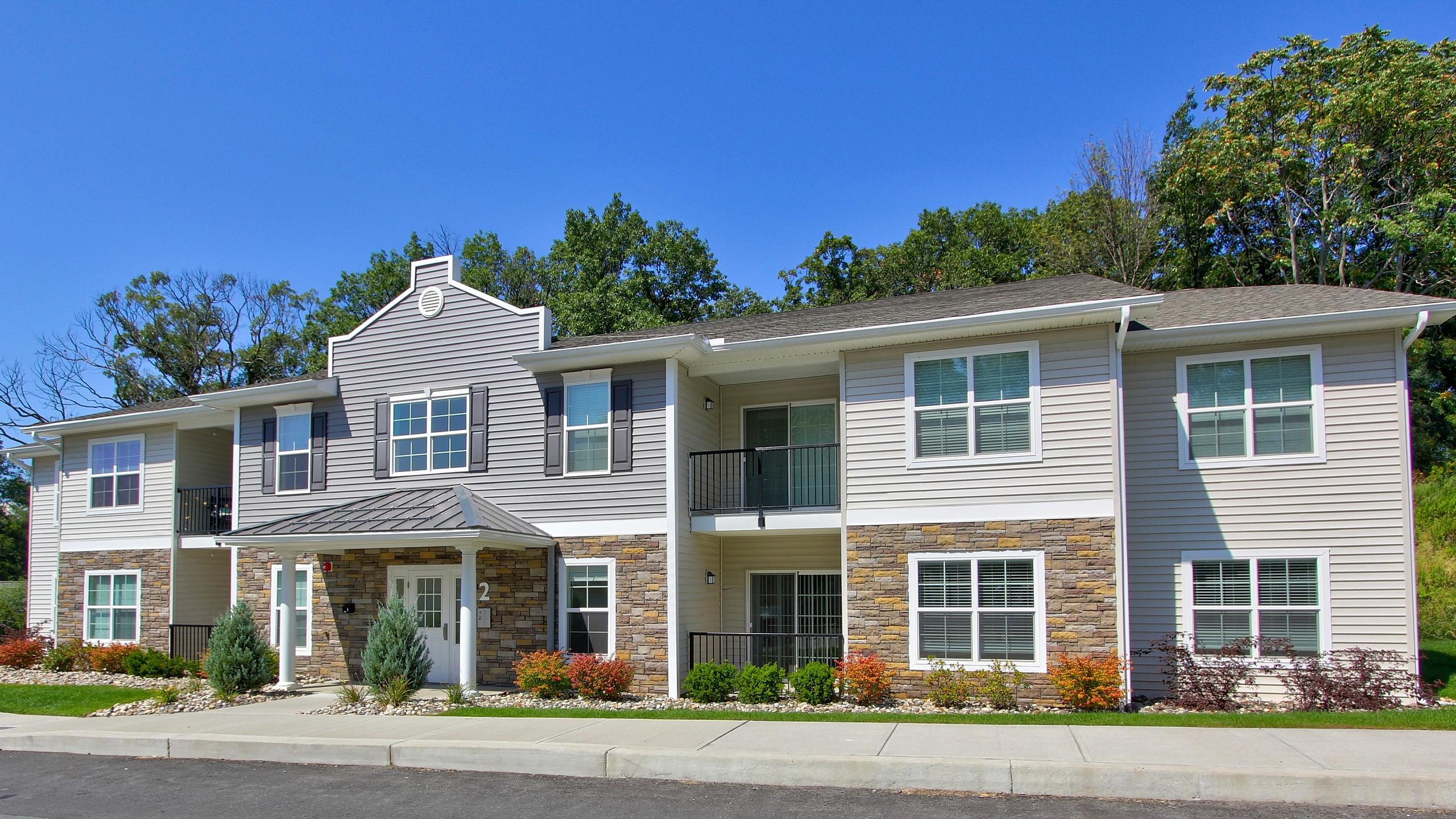 Apartment building exterior with landscaped grounds at Van Allen Apartments in Troy, NY