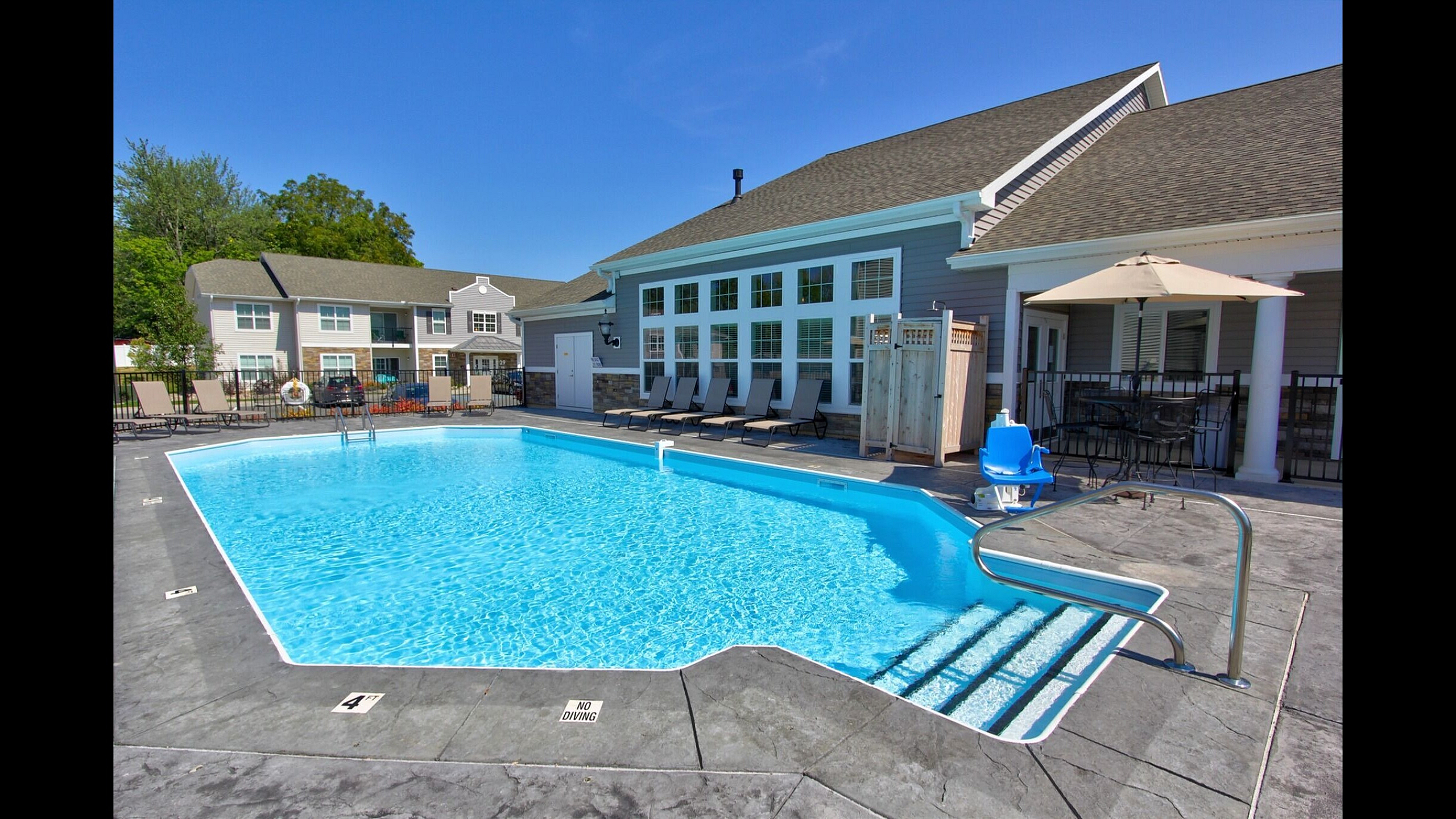 Outdoor saltwater pool with lounge seating and sun deck beside the clubhouse at Van Allen Apartments