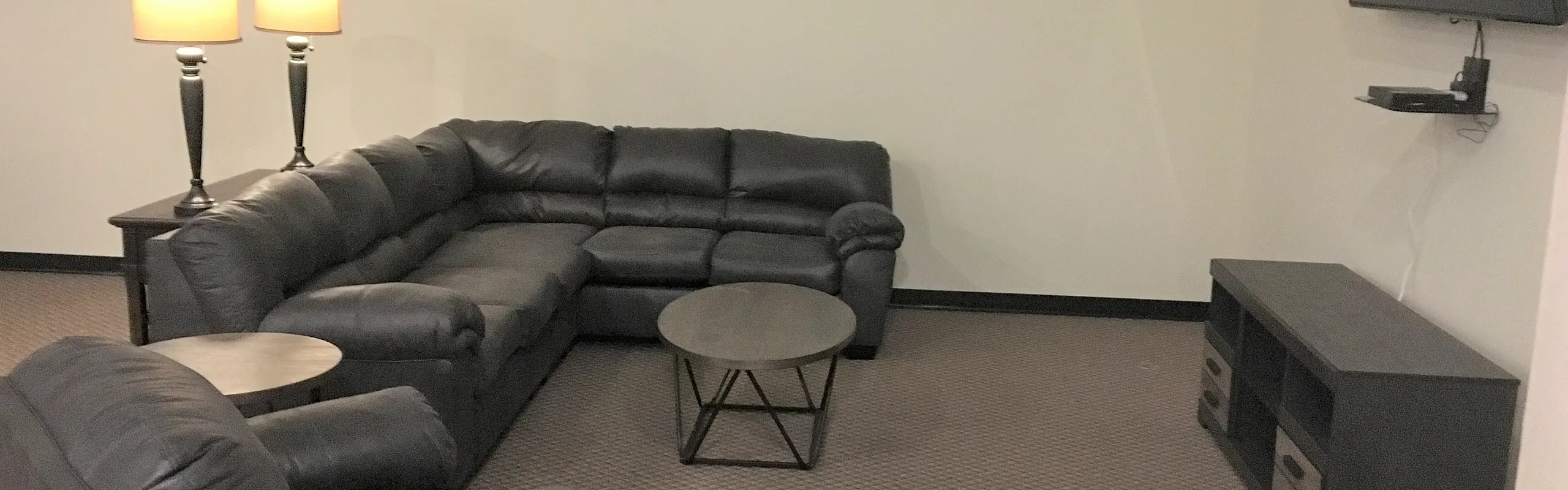 Resident lounge with sectional seating and fireplace at Draper Lofts in Rotterdam, NY