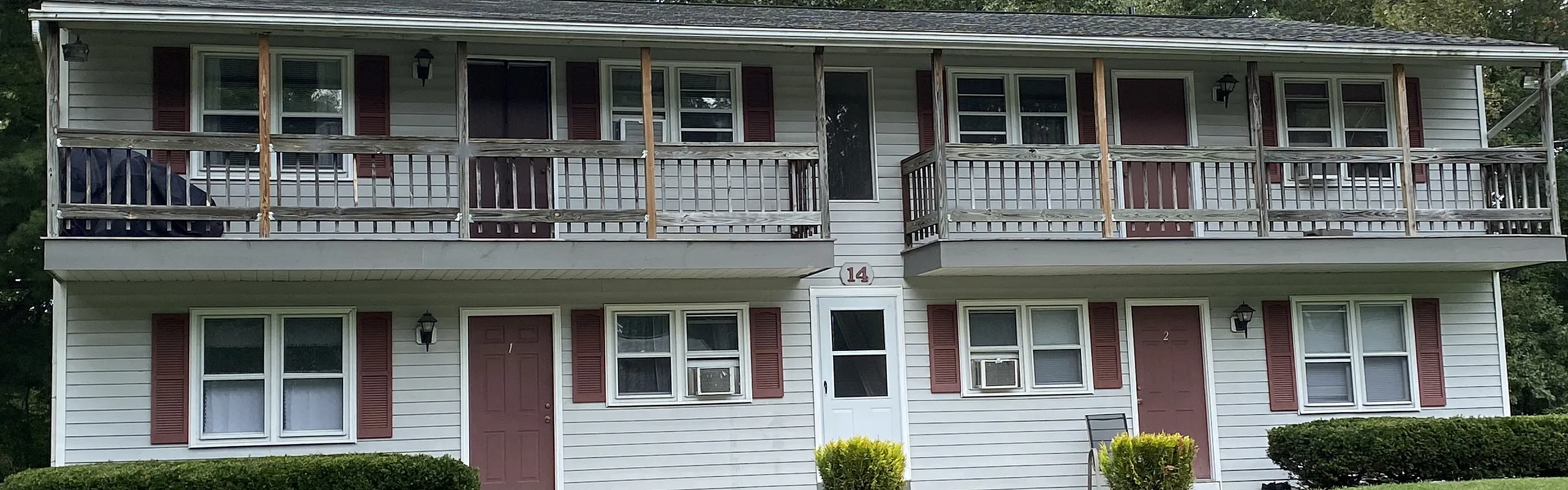 Two-story apartment building with balconies and landscaped lawn at Halfmoon Garden Apartments in Clifton Park, NY