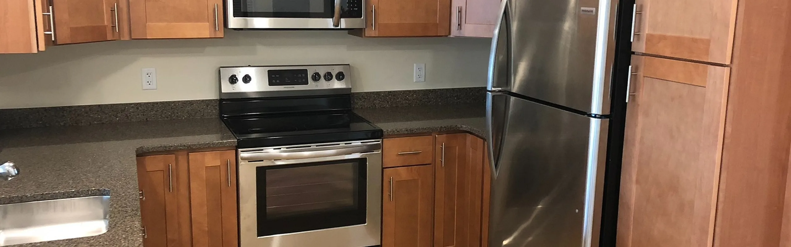 Full-size kitchen with stainless steel appliances and granite counters at Mohawk Riverfront Apartments in Cohoes, NY