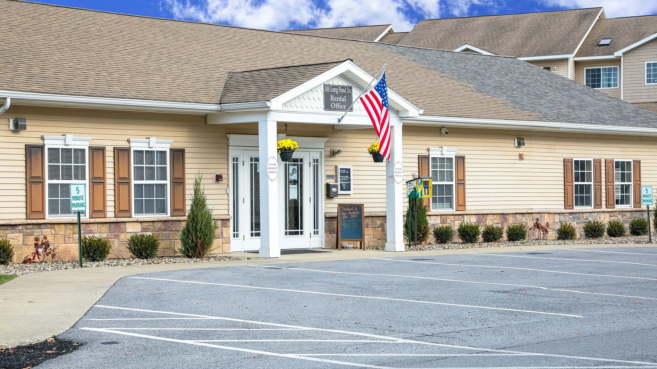 Clubhouse exterior with columned entrance at Long Pond Village Apartments in Schenectady, NY
