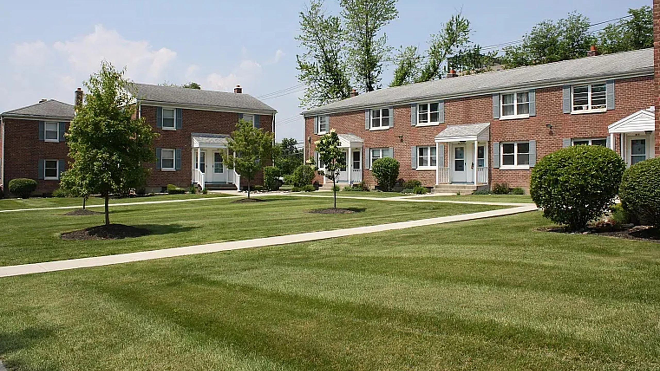 Brick townhomes and lawn at Adams Park Apartments, Albany NY