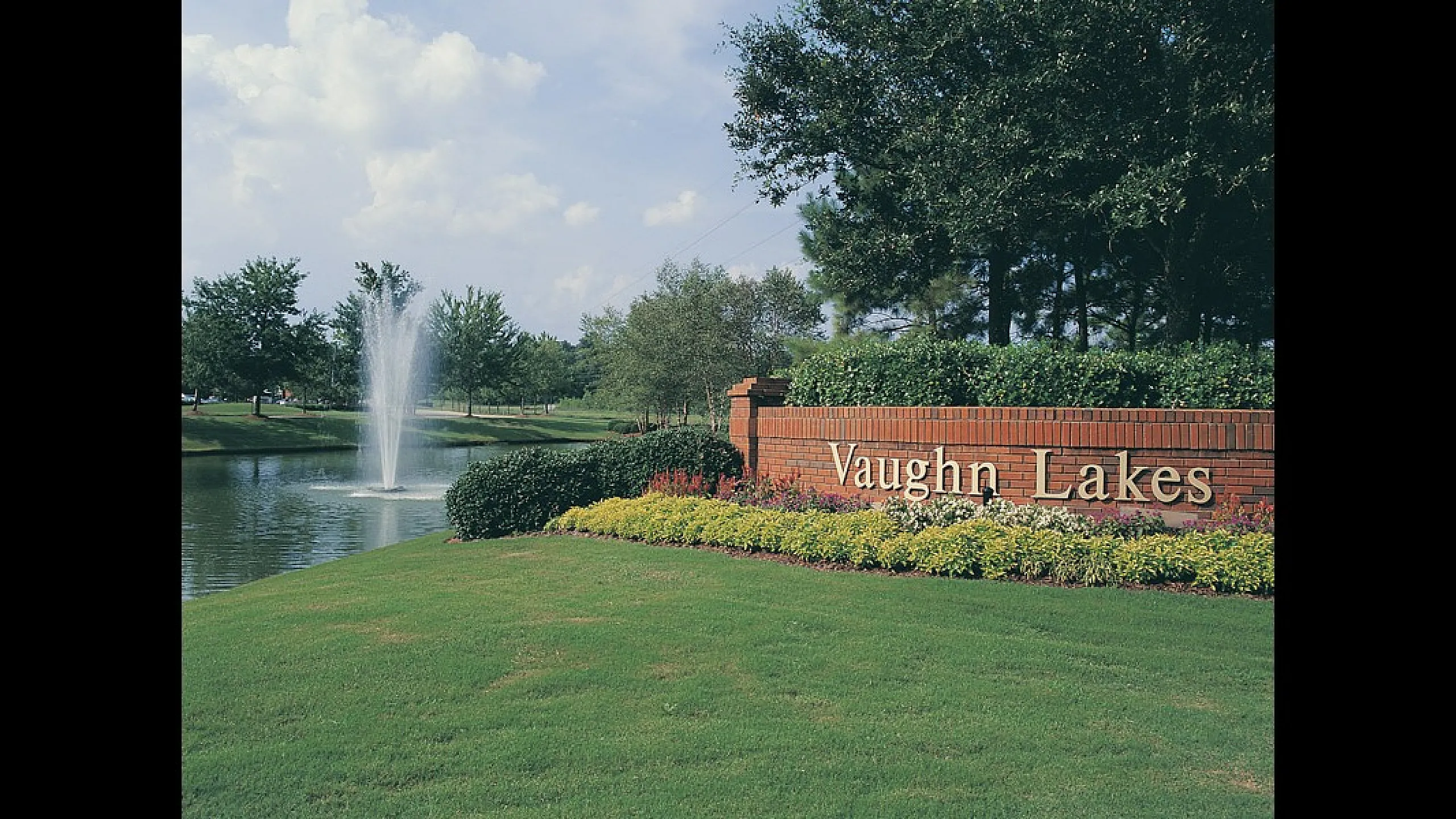 Serene landscape at Vaughn Lakes with lush greenery, a tranquil pond, and a central water fountain.
