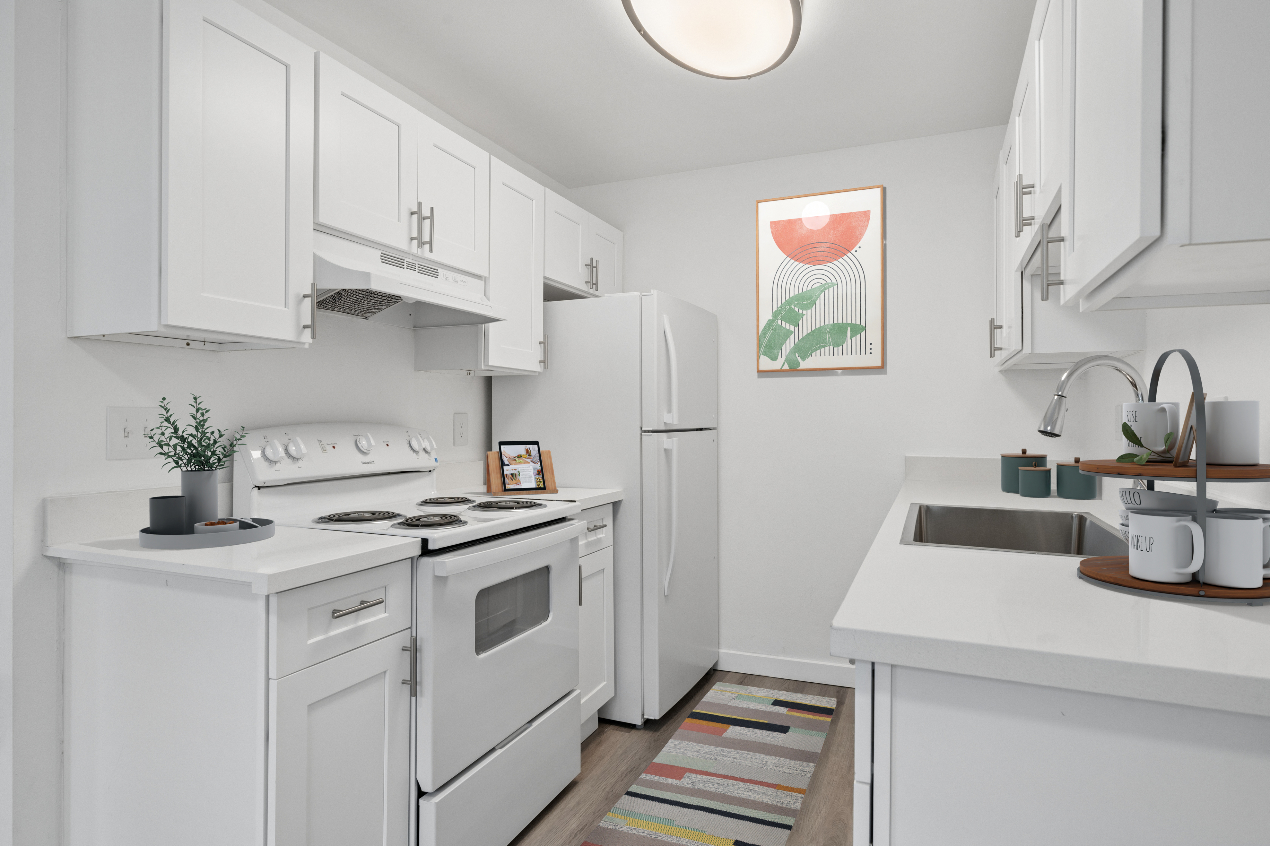 Chic modern kitchen with sleek white cabinets, stylish decor, quartz countertops and a cozy ambiance.