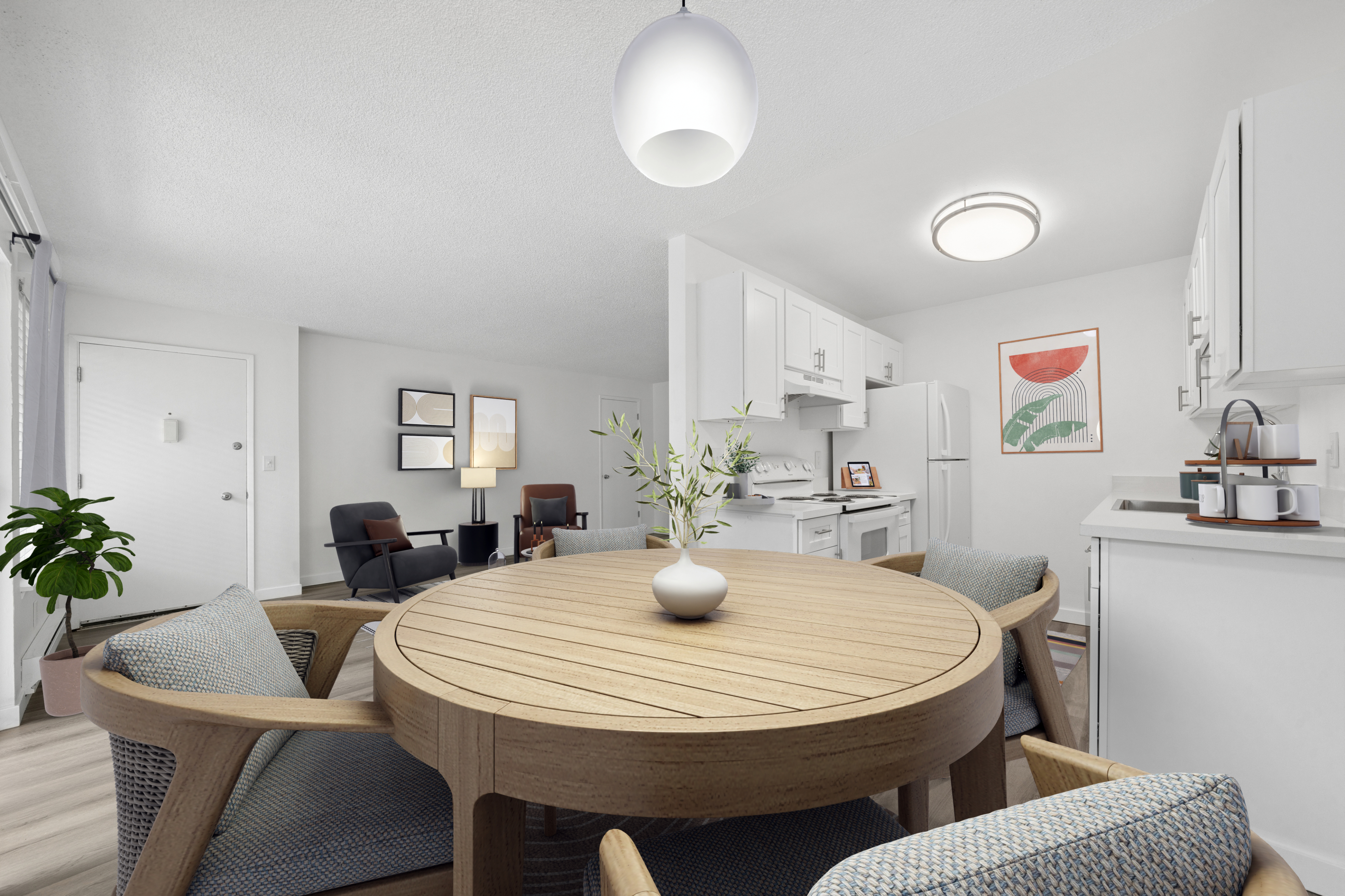 Bright and modern open-concept dining and kitchen area with sleek white cabinets, stylish round wooden table, and contemporary decor.