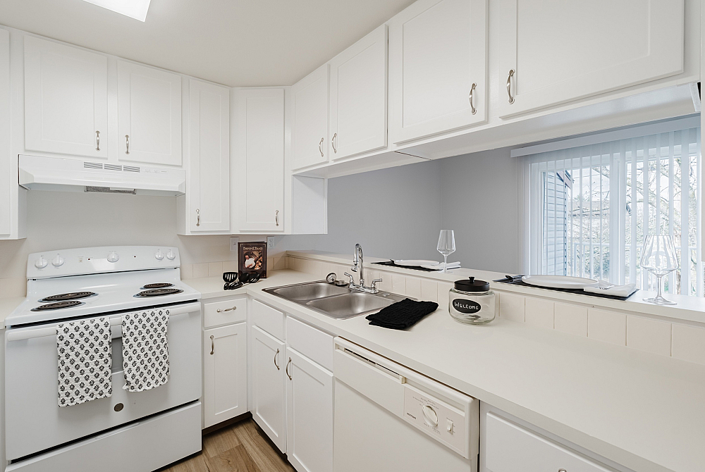 Modern apartment kitchen with sleek cabinetry, white appliances, and a spacious layout.