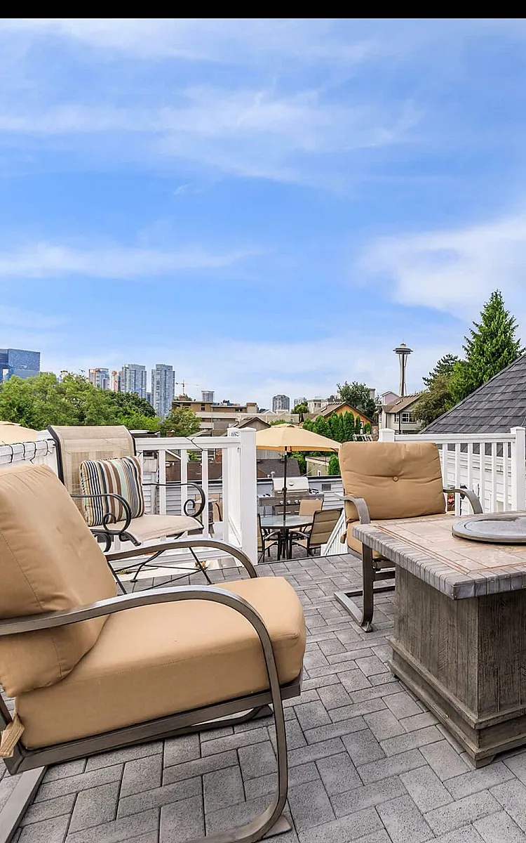 Charming rooftop patio with cozy seating, offering stunning city skyline views, perfect for relaxation and entertaining.
