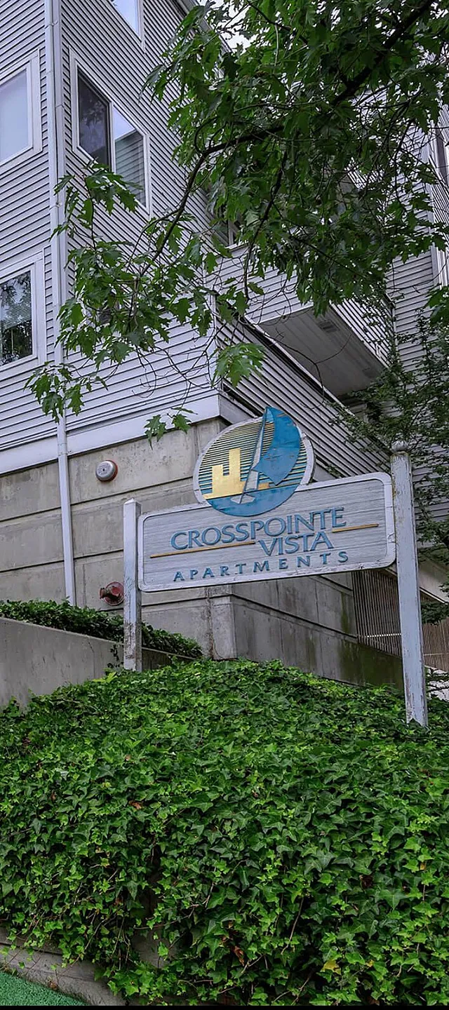 Charming modern apartment exterior at Crosspointe Vista Apartments, surrounded by lush greenery and a welcoming entrance.