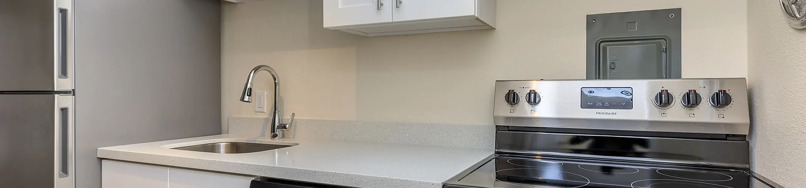 Modern kitchen with stainless steel appliances, sleek white cabinetry, and stylish countertops.