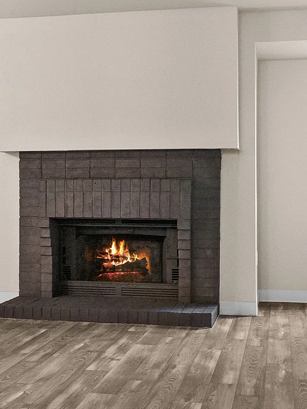 Spacious living room with elegant hardwood flooring, cozy fireplace, and large windows offering scenic views.