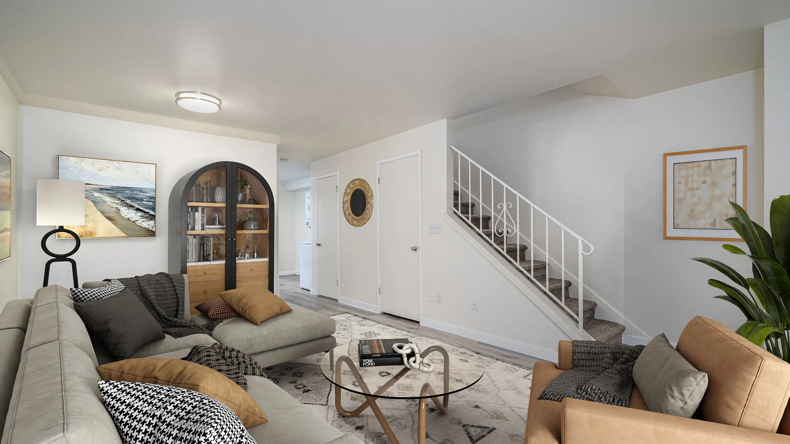 Inviting living room featuring modern decor, plush sofas, elegant lighting, and a chic staircase leading upstairs.