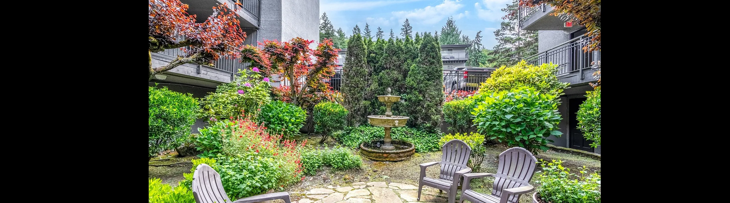 Enchanting garden oasis with vibrant flowers, lush greenery, stone pathway, and a central water fountain, perfect for relaxation.