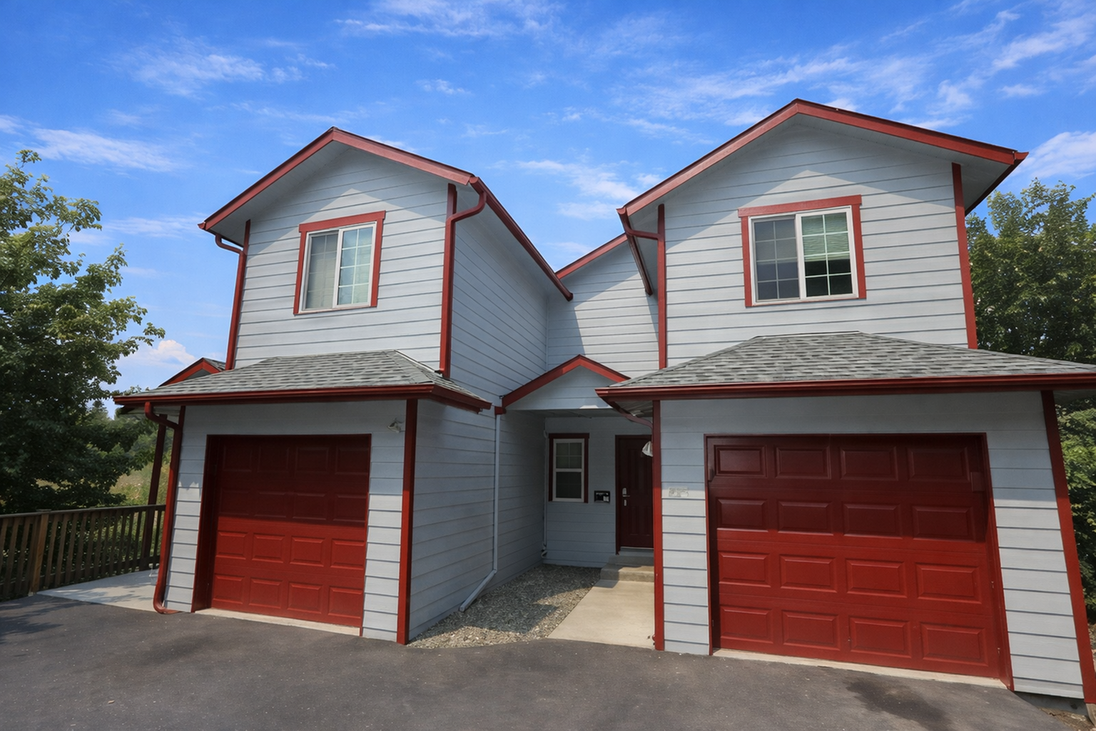 Coug Housing two-story house with twin garages, red trim accents, and a welcoming driveway.