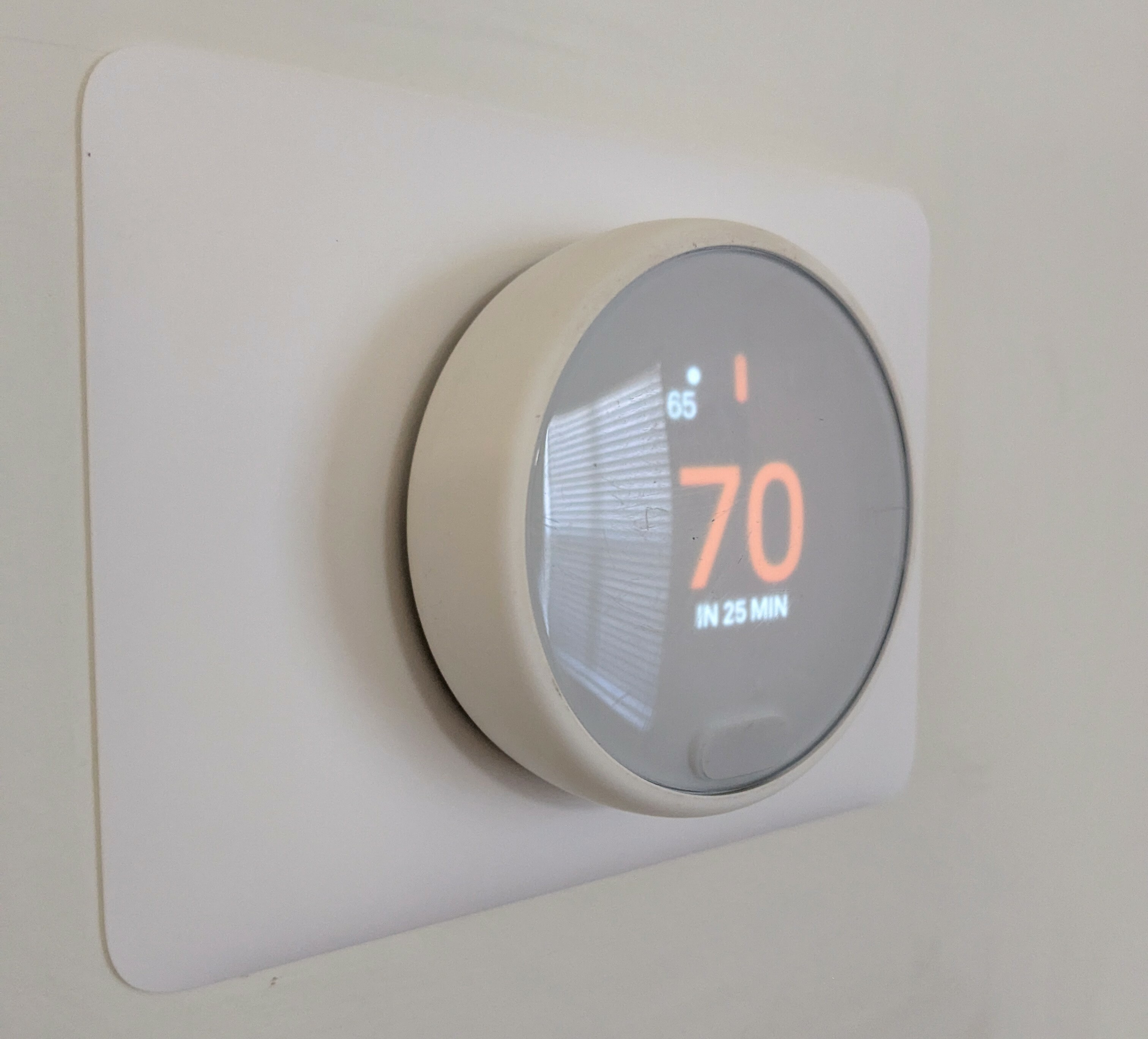 Close-up of a modern smart thermostat displaying a temperature of 70 degrees, enhancing home comfort.