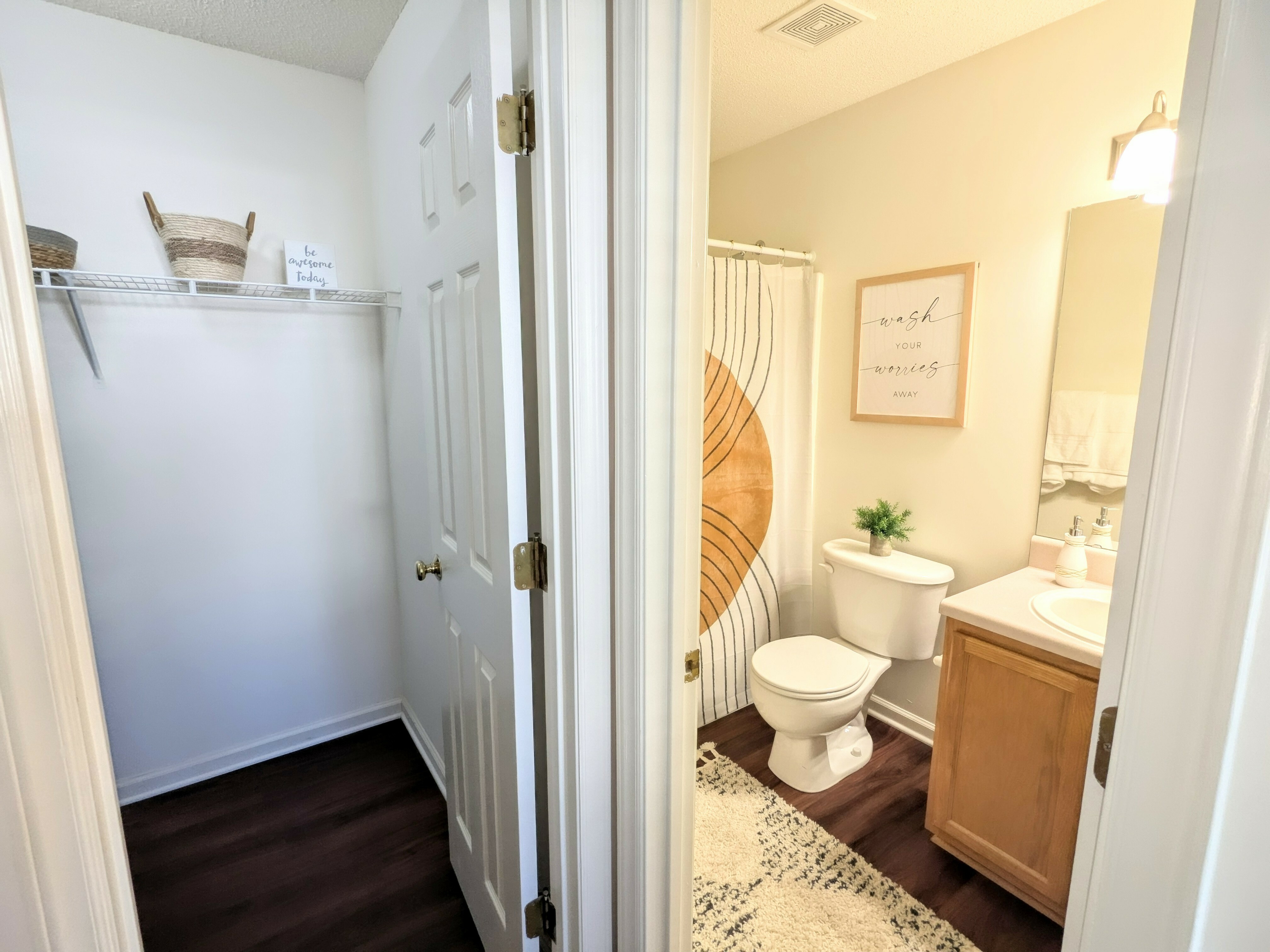 Stylish bathroom with modern decor and an adjoining organized closet featuring baskets.