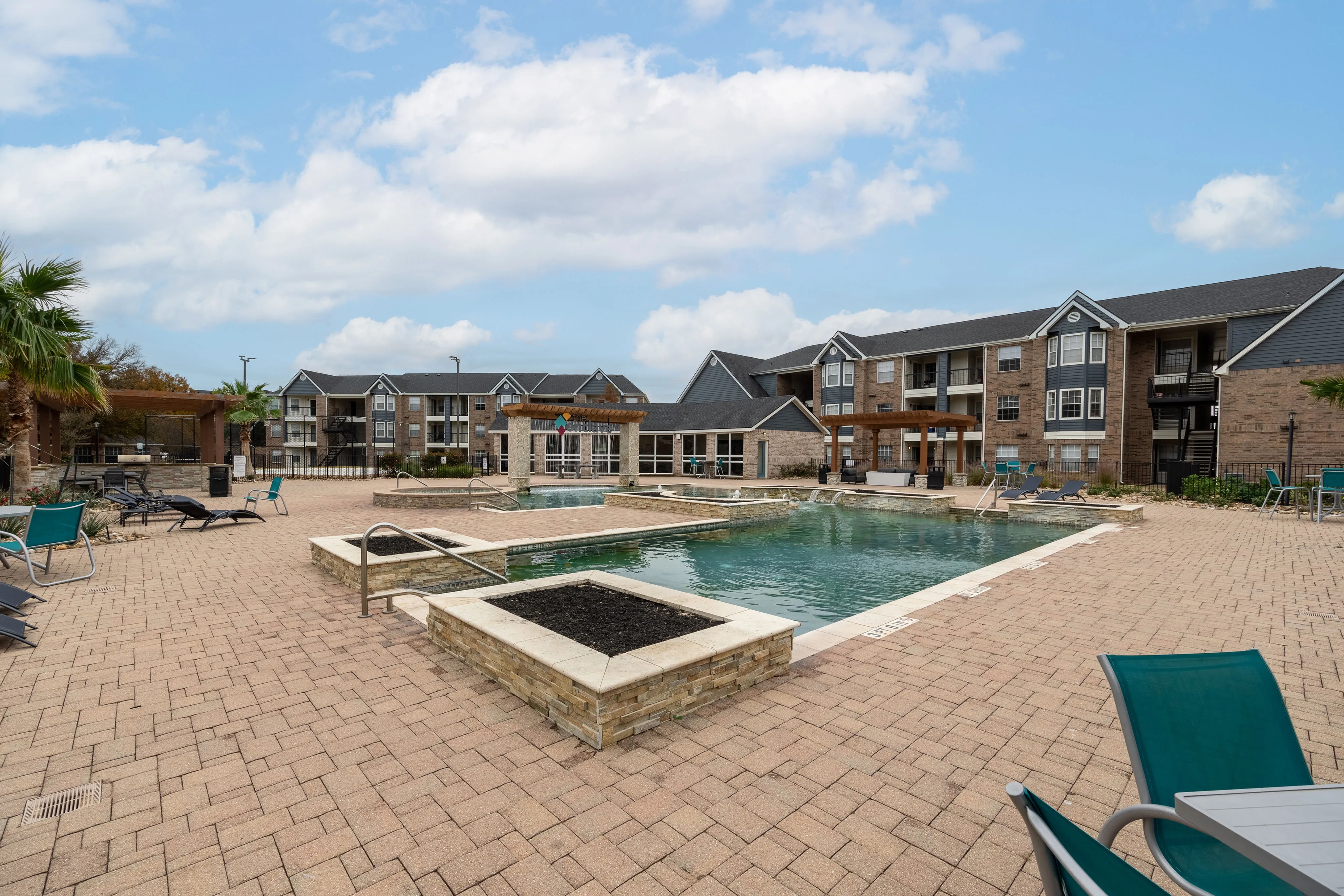 Spacious apartment complex with a large outdoor swimming pool and modern lounge area.