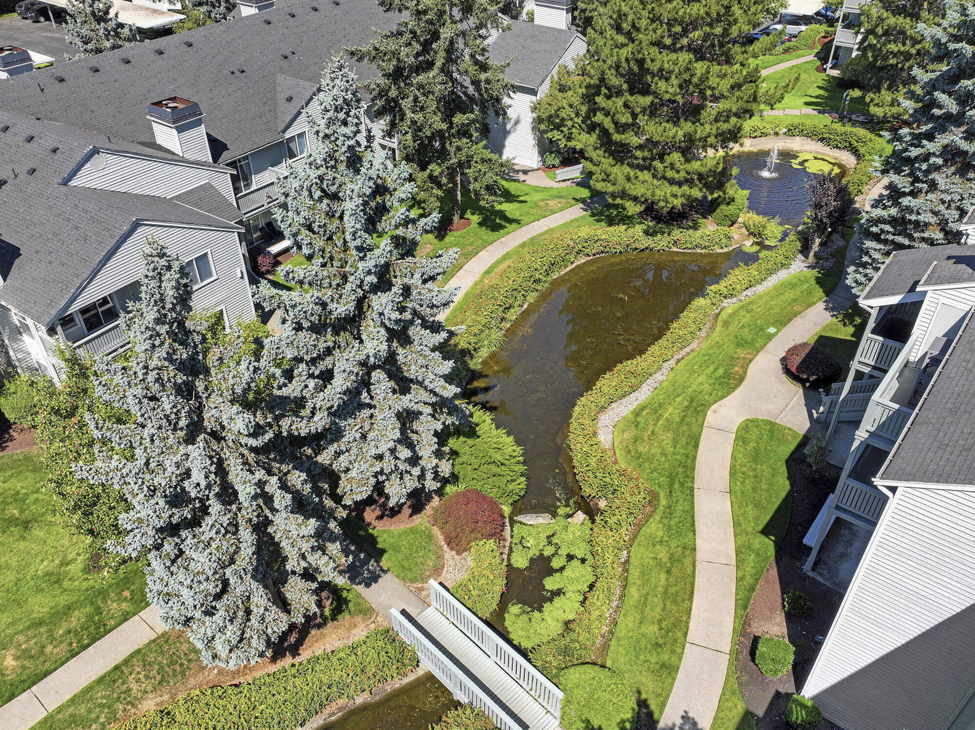 Lush landscaping and mature trees throughout Canyon Springs apartments in Lynnwood, WA