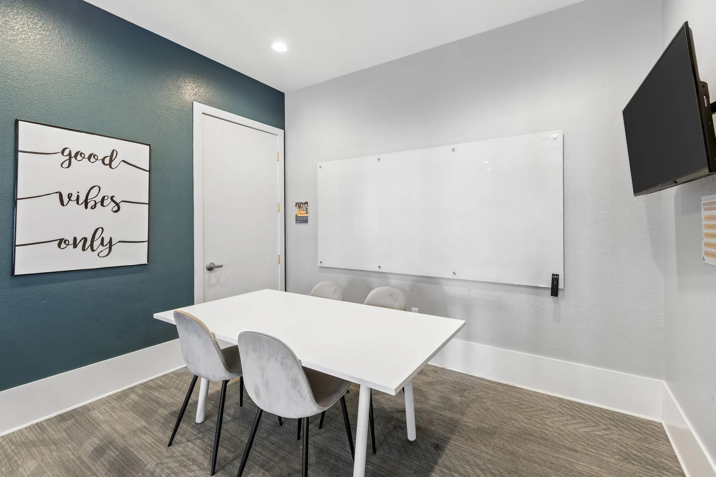 Highlander at North Campus study room with white table, comfortable chairs, and good vibes only wall decor in Riverside CA