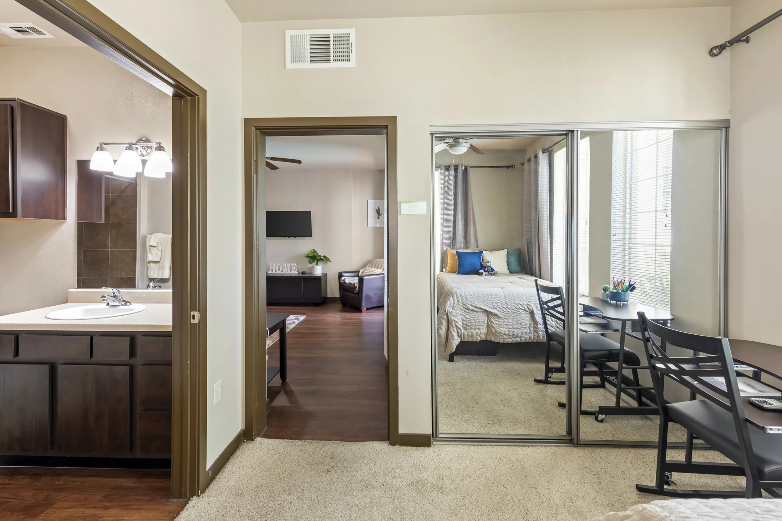 Highlander at North Campus apartment interior with cozy bedroom, mirrored closet, and warm modern living room in Riverside CA