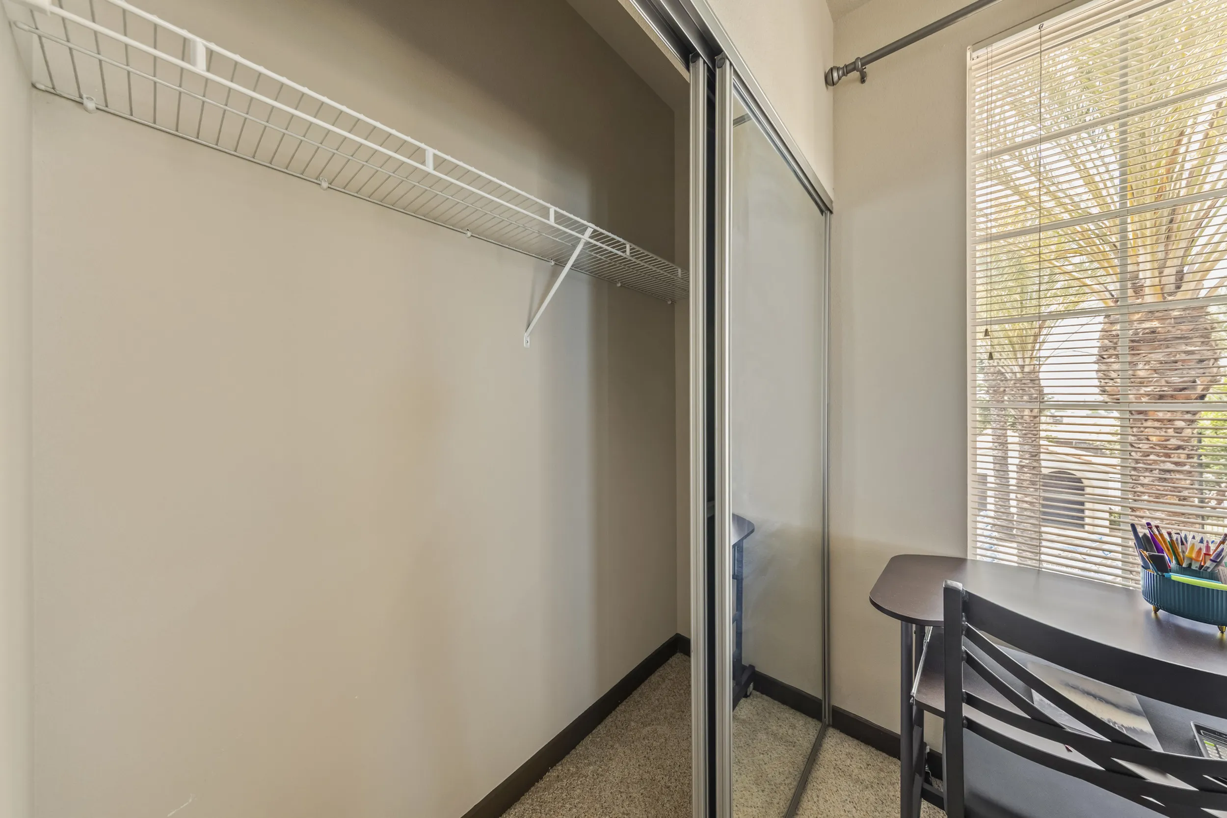 Highlander at North Campus apartment bedroom with sliding mirrored closet doors and sunlit desk study nook in Riverside CA