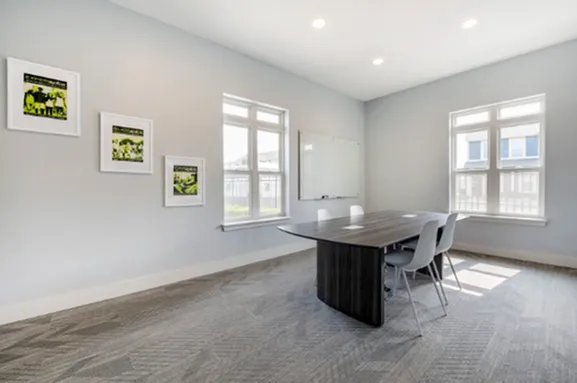 Bright modern study room with conference table and natural light at The Cottages on Lindberg in West Lafayette, IN