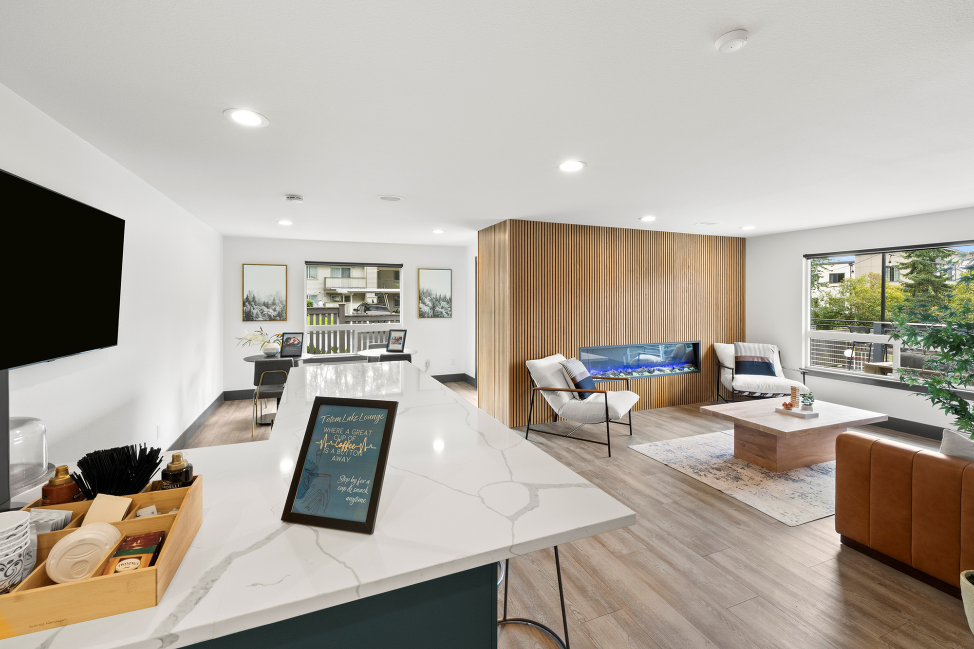 Bright and modern living space with elegant wood accents, featuring a sleek electric fireplace, comfortable seating, and contemporary decor.