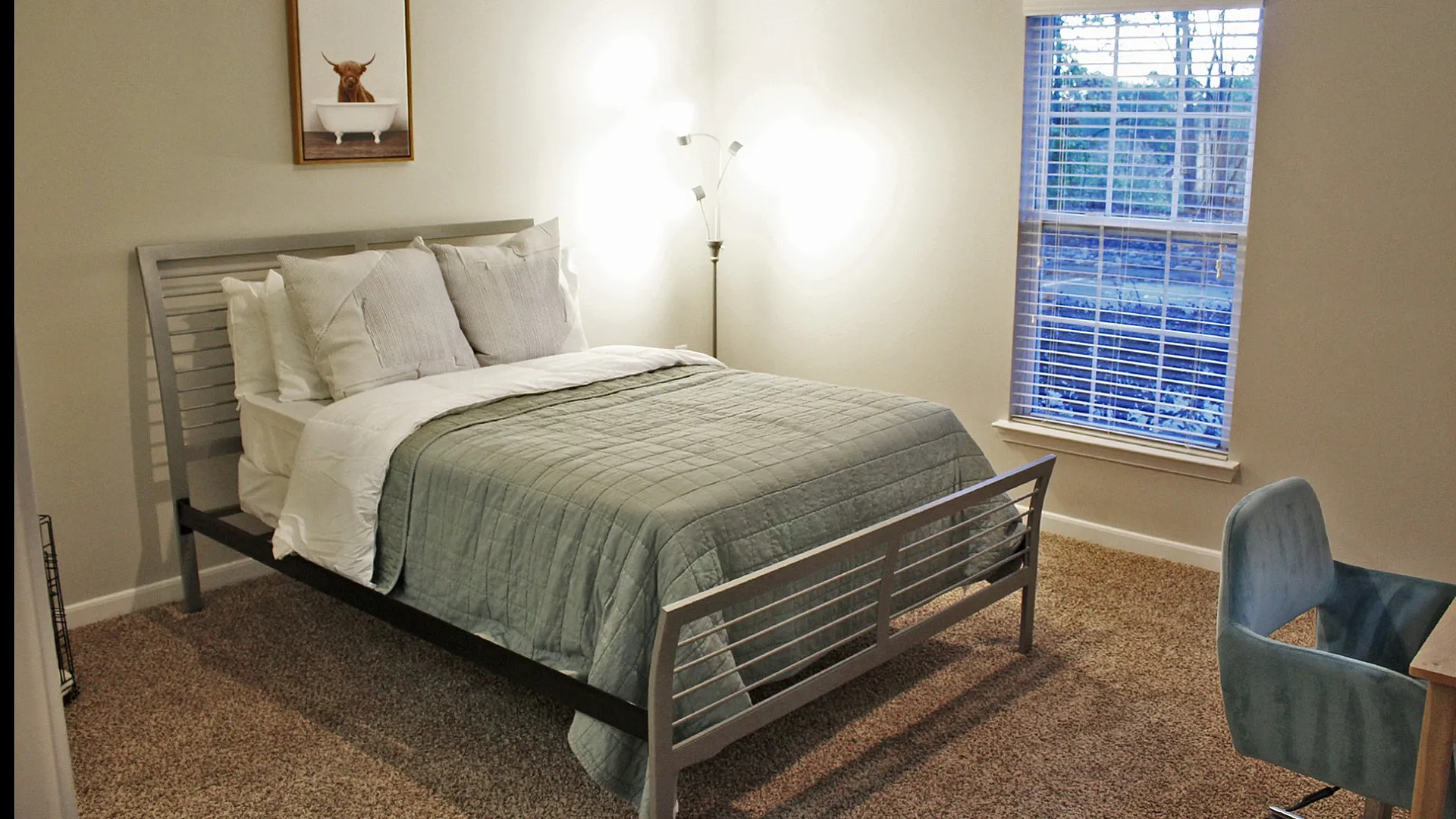 Inviting bedroom featuring a comfortable bed with elegant decor and a large window inviting natural light.
