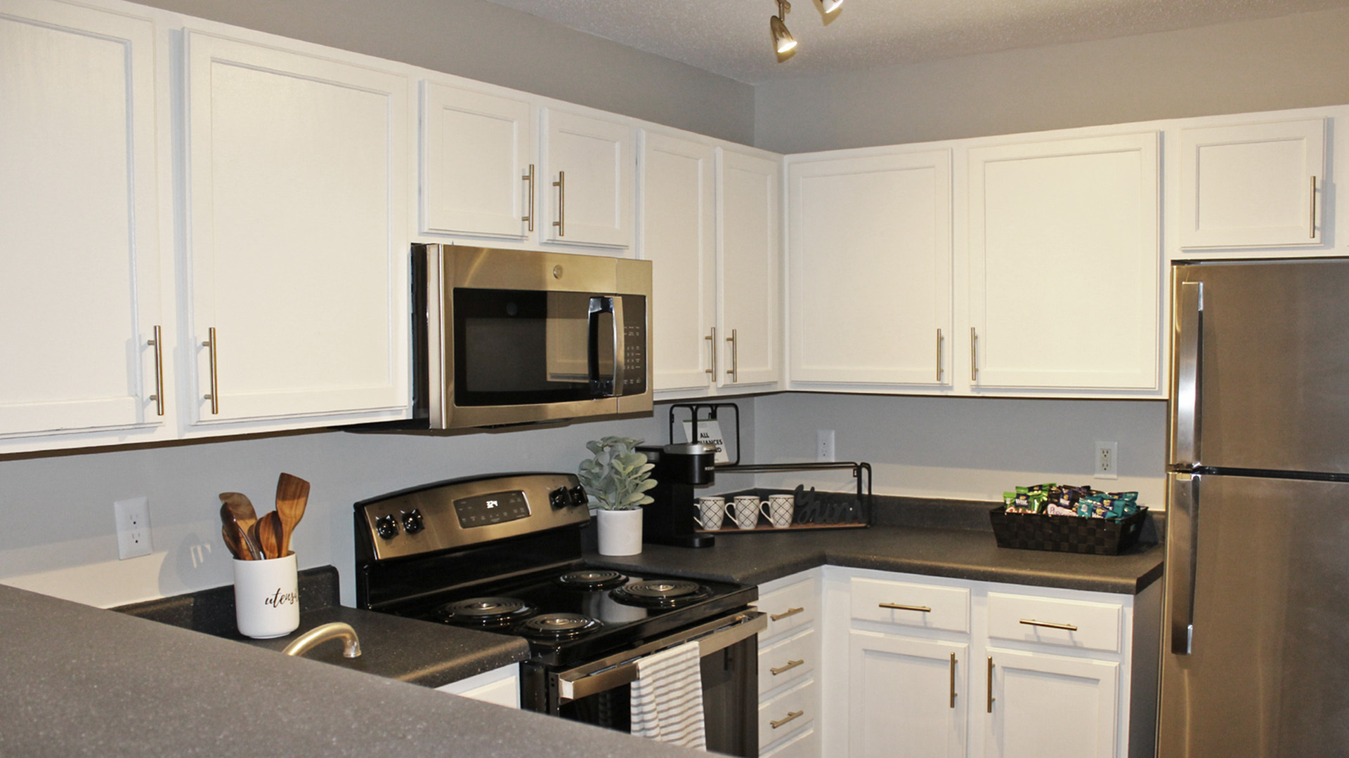 Modern kitchen with sleek white cabinetry, stainless steel appliances, and elegant countertop.