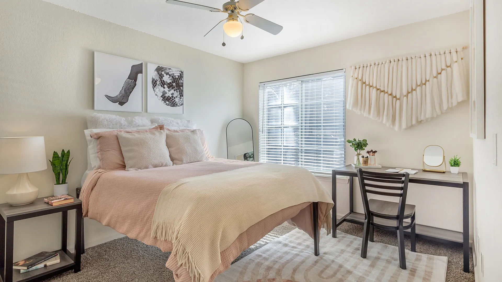 Bright and inviting bedroom with neutral decor, featuring a plush bed, study desk, and chic artwork.