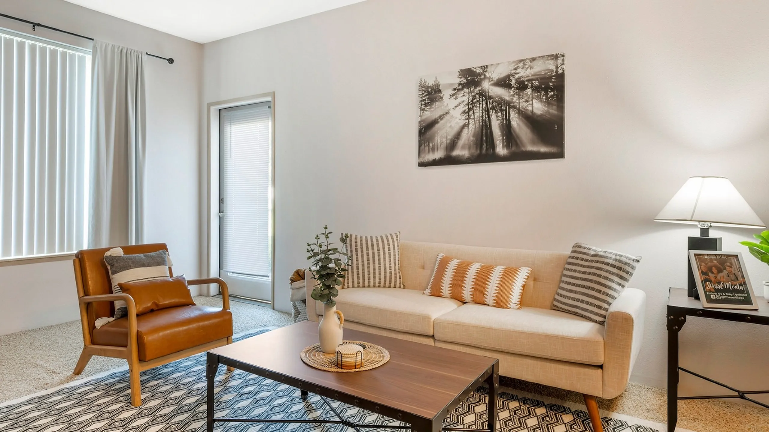 Bright and inviting living room with modern decor, featuring a cozy beige sofa, elegant wooden coffee table, and stylish accent chair, perfect for relaxation and entertaining.