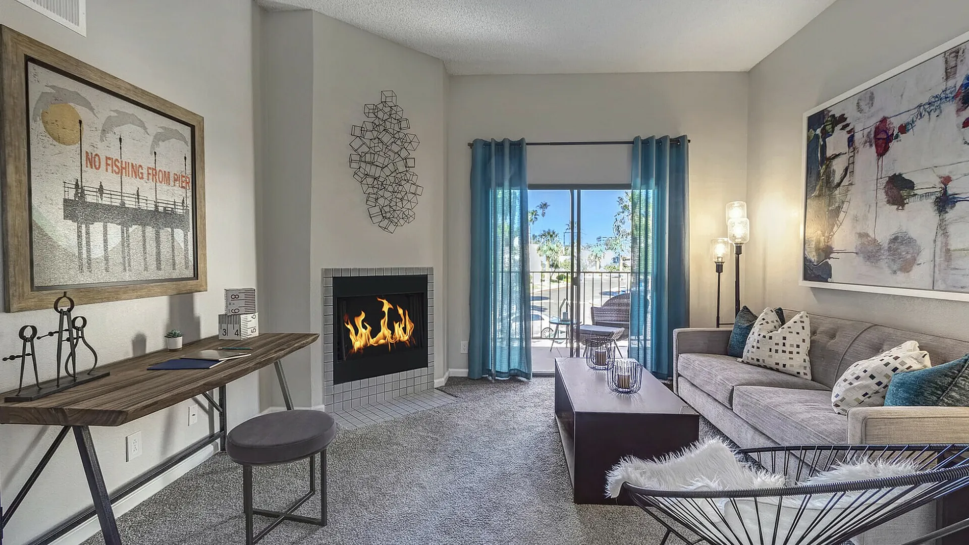 Cozy living room with modern fireplace, chic decor, and a balcony view through elegant blue curtains, perfect for relaxation.