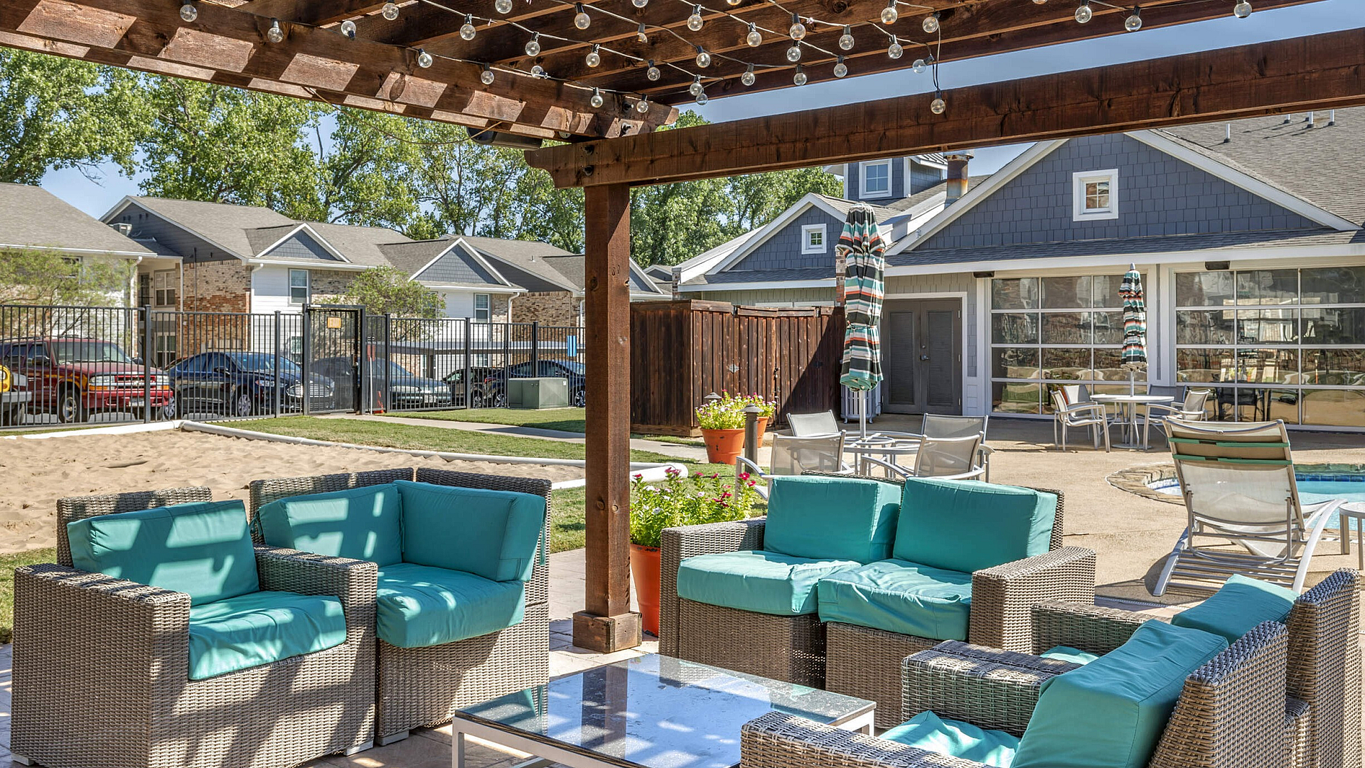 Outdoor cabana patio with wicker furniture and string lights near the pool at The Venue student apartments in Denton, TX near University of North Texas