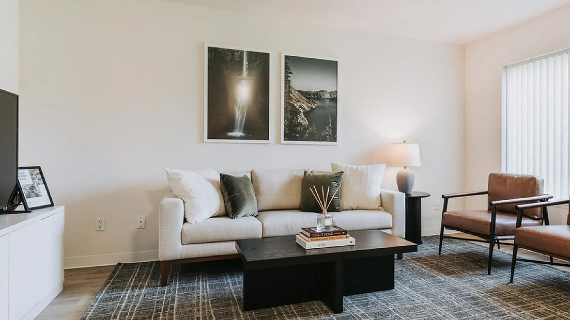 Elegant apartment living room with cozy beige sofa, modern armchairs, and natural light from large windows at Forest Hills Eugene OR