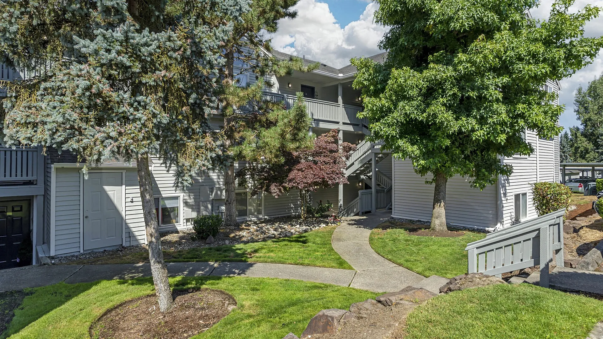 Canyon Springs apartment exterior with tranquil setting surrounded by lush greenery and mature trees in Lynnwood Washington