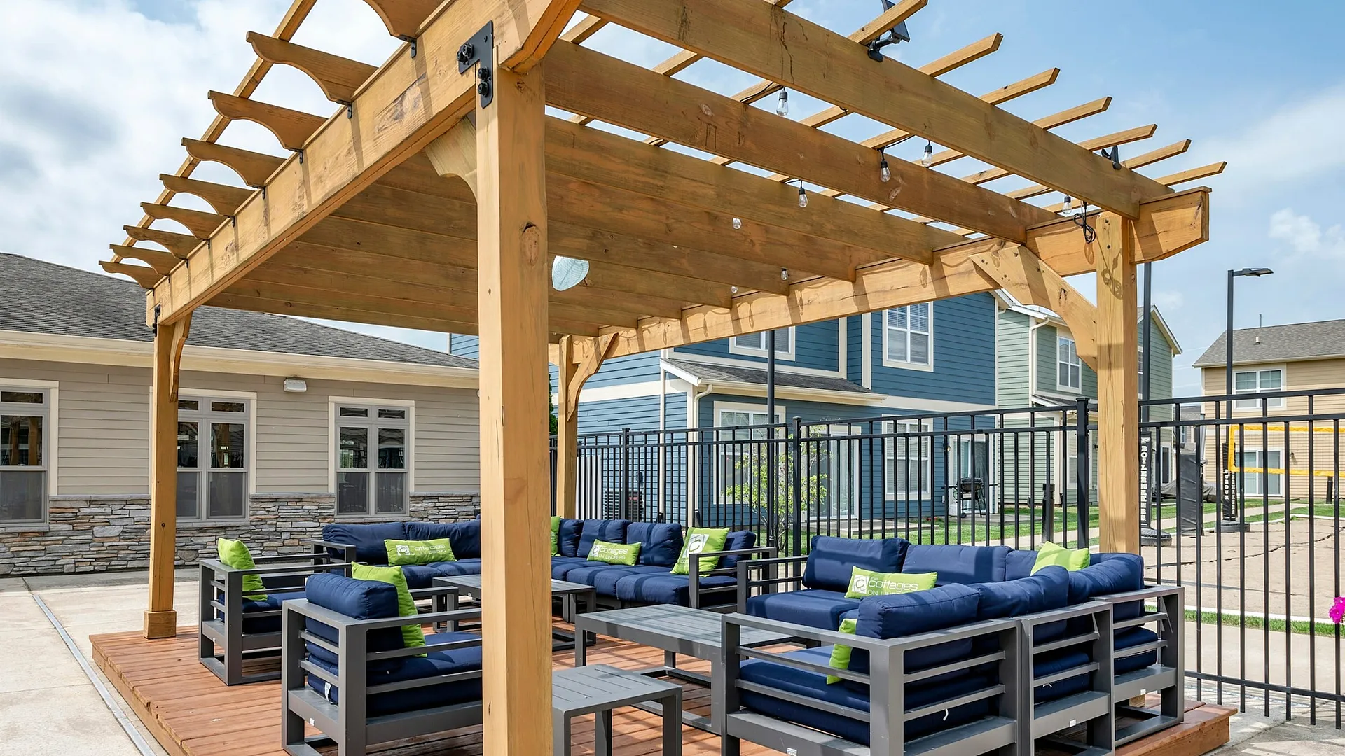 Poolside lounge with wooden pergola and navy seating at The Cottages on Lindberg in West Lafayette, IN