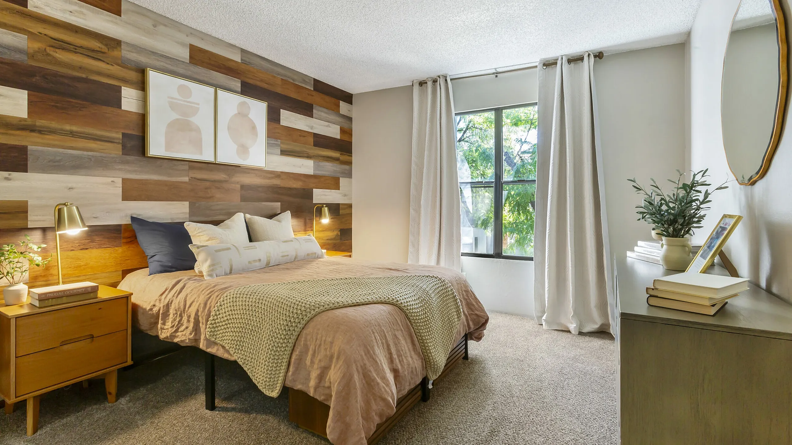 Stylish apartment bedroom with wood accent wall and natural light at 255 North near Downtown Tucson, AZ