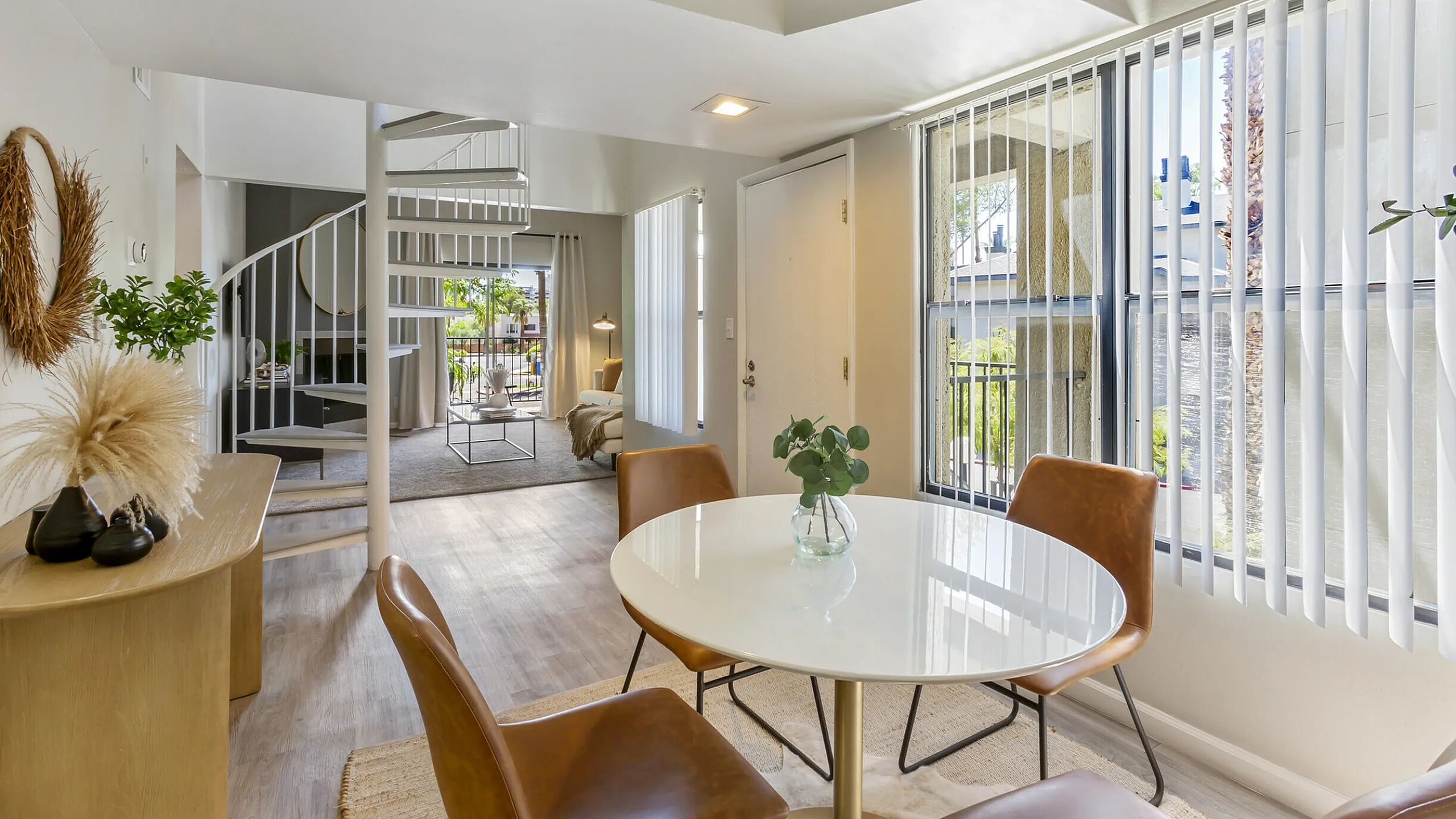 Spacious apartment living area with spiral staircase and modern dining at 255 North near Downtown Tucson, AZ