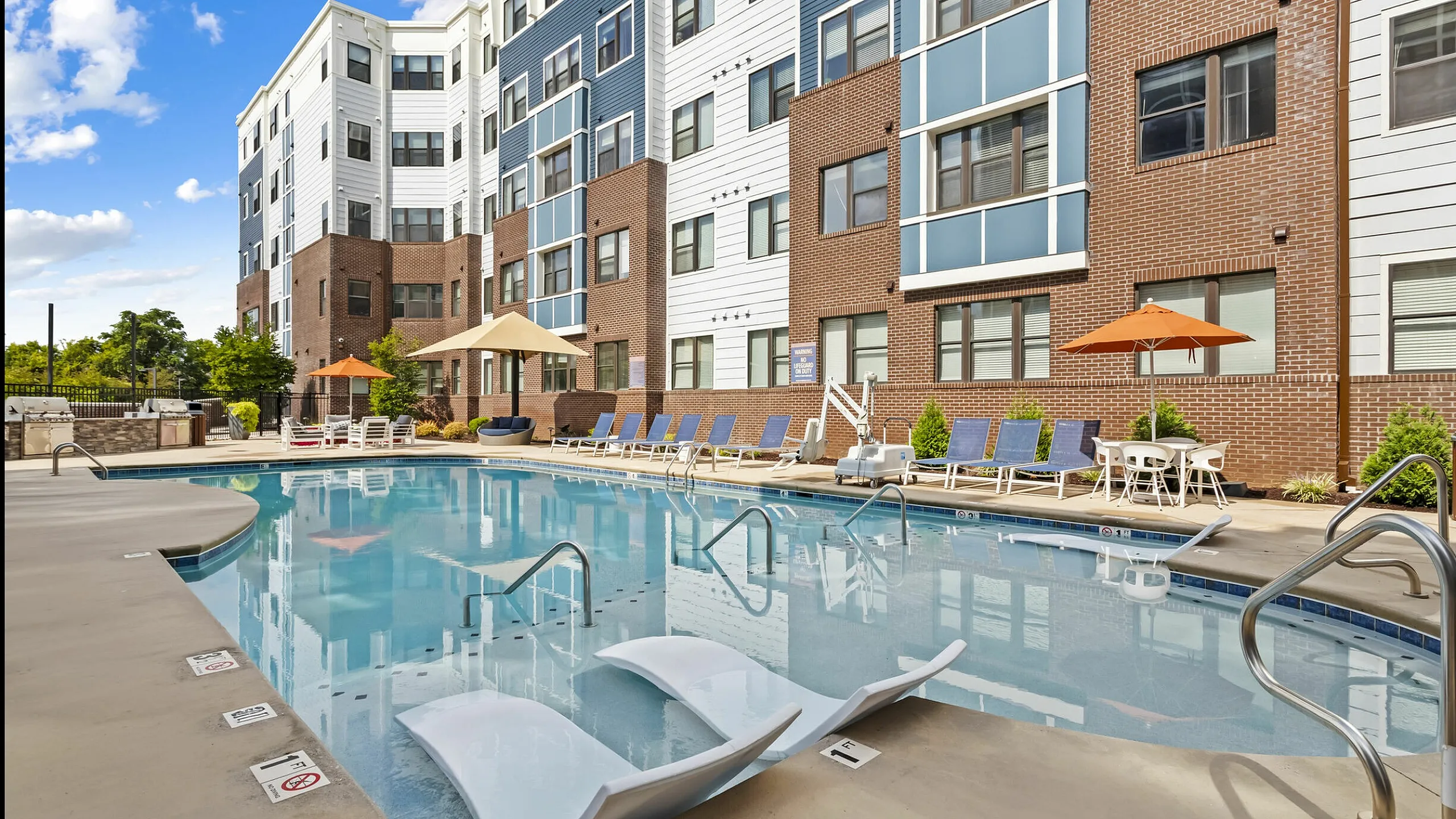 Resort-style outdoor pool with lounge seating at 303 Flats student apartments in Knoxville, TN