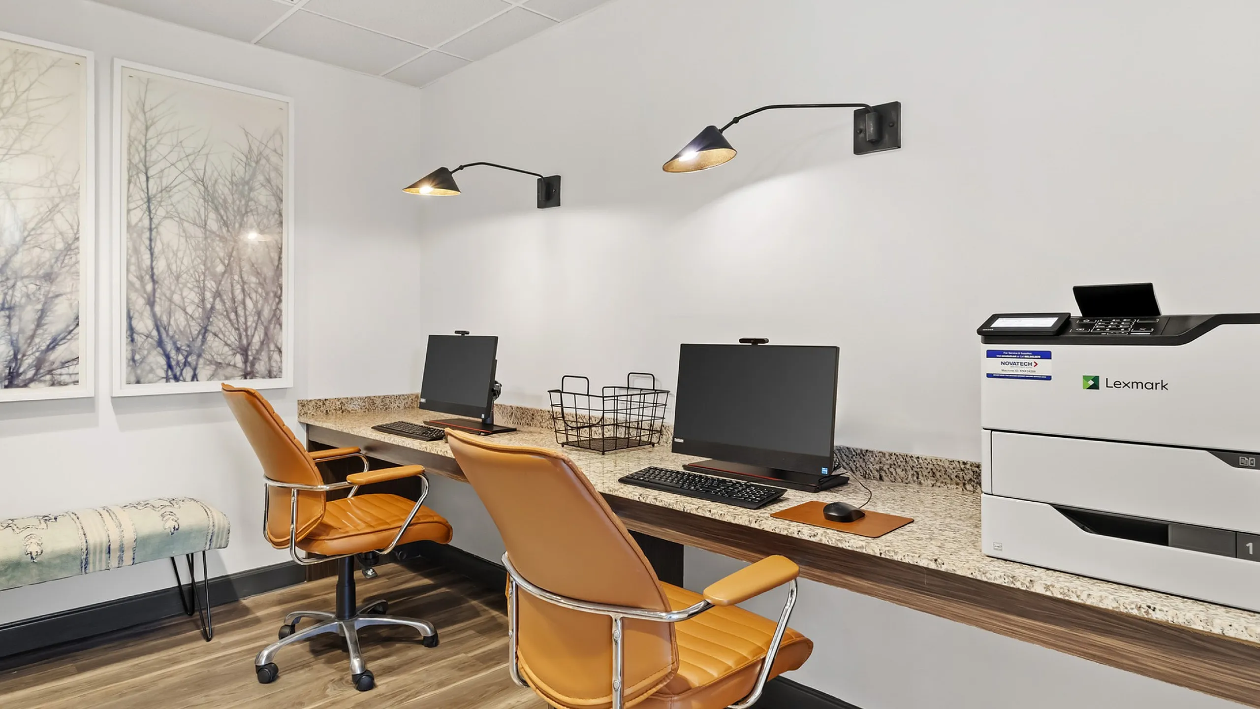 Modern 303 Flats office space featuring sleek computer stations, vibrant orange chairs, and stylish artwork, creating an inspiring work environment.