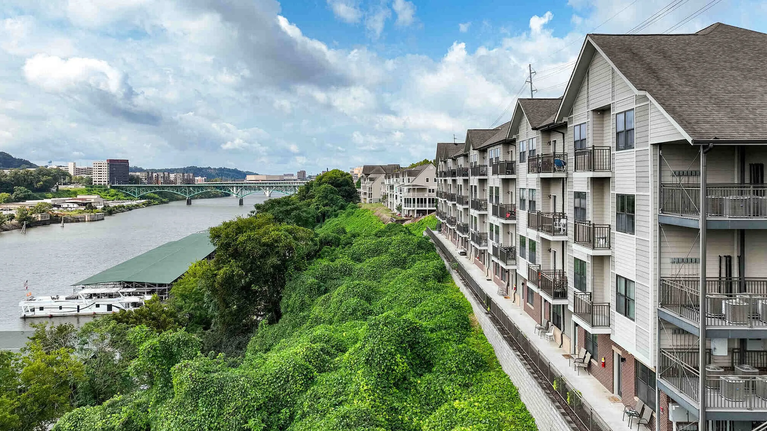 Aerial view of The Landings riverside apartment community along the Tennessee River with scenic bridge and lush greenery Knoxville TN