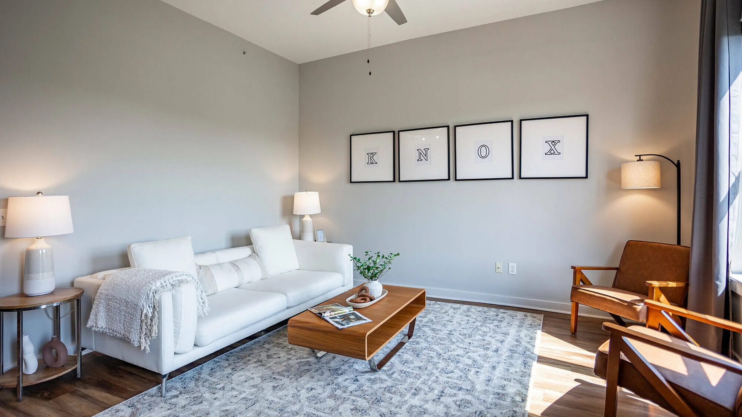 Bright and elegantly furnished model living room with plush sofa and stylish decor at The Landings apartments Knoxville TN