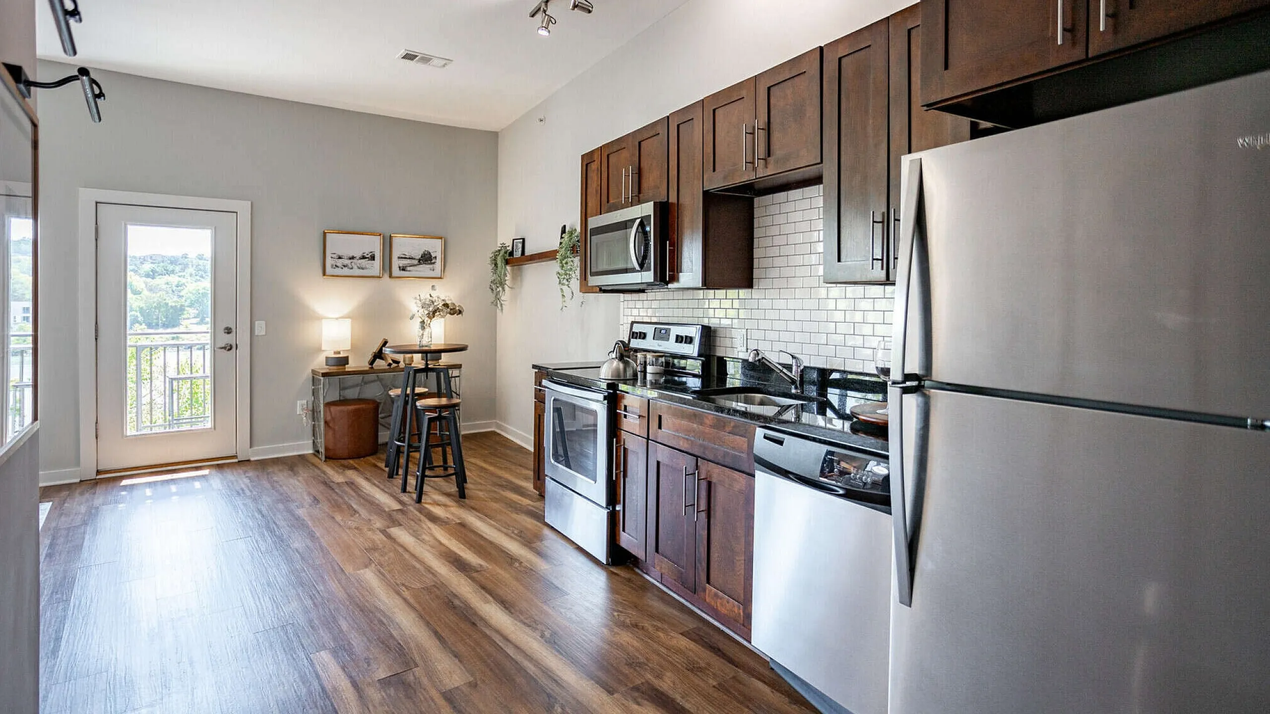 Model kitchen with dark wood cabinets stainless steel appliances and subway tile backsplash at The Landings Knoxville TN